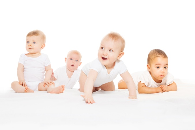 Four cute babies crawl in a row wear white body